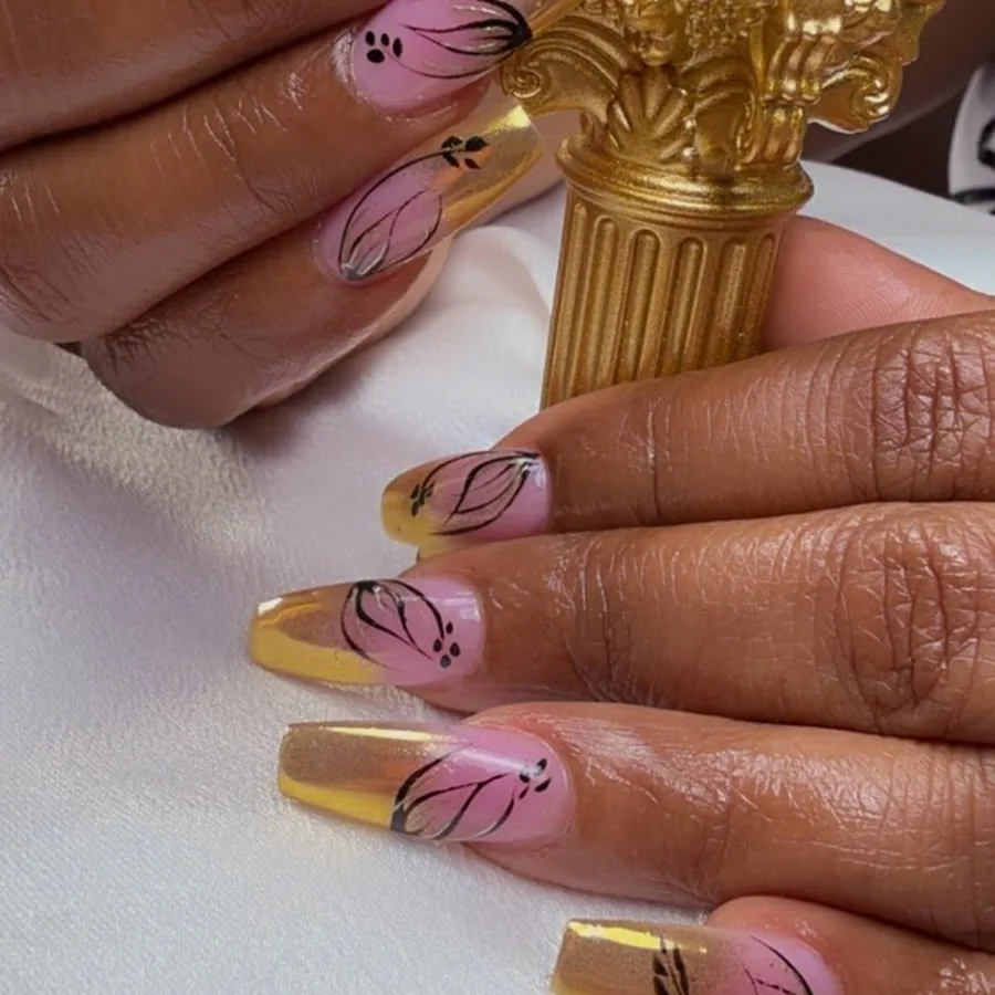 Long coffin acrylic nails with hand painted pink and black floral art at Yudy's Queen Nails in Palm Beach Gardens