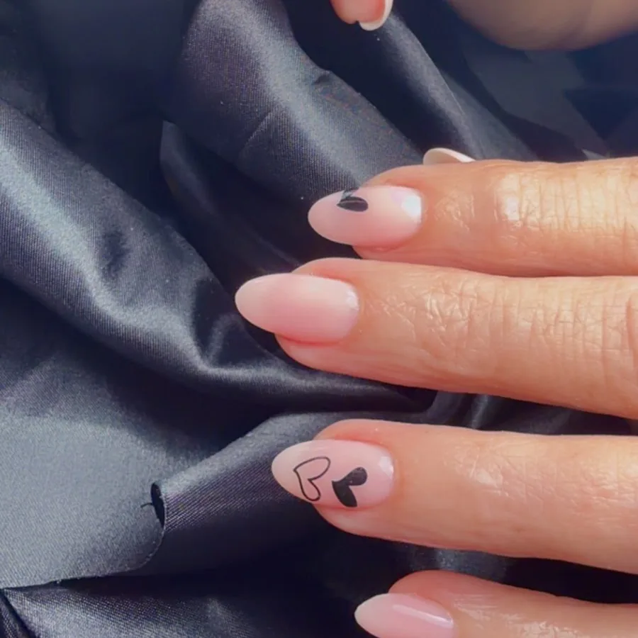 Almond gel manicure with black heart line art accents at Yudy's Queen Nails in Palm Beach Gardens